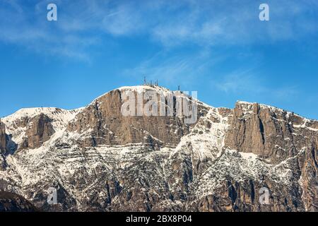 Pic de la Paganella ou cima Roda (2125 m), Alpes enneigées avec les antennes de la station météorologique, vue du Trento, Trentin, Italie. Banque D'Images