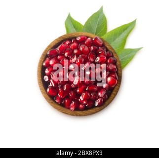Graines de grenade rouge. Grains d'un grenade dans un bol en bois, isolés sur fond blanc. Vue de dessus. Banque D'Images