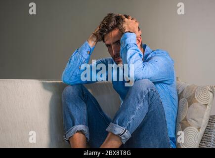 portrait de style de vie de jeune attrayant et beau triste latin homme assis fatigué et déprimé à la maison canapé canapé se sentant submergé et inquiet suffit Banque D'Images