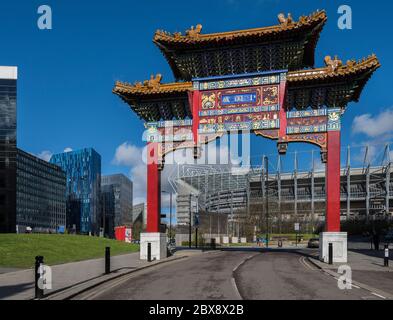 Porte d'entrée du quartier chinois de Newcastle upon Tyne avec le stade Newcastle United FC à St. James' Park et les bâtiments de l'université de Newcastle en arrière-plan. Banque D'Images