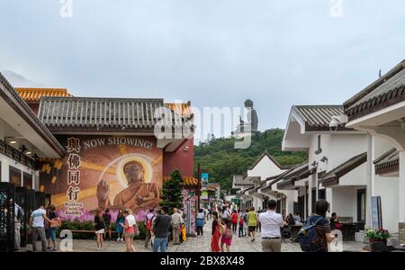 Vue sur le village de Ngong Ping avec la statue de Tian Tan Big Buddha au loin, sur l'île de Lantau, Hong Kong Banque D'Images