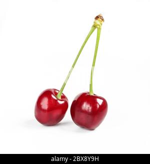 Deux cerises fraîches biologiques à tige verte isolées sur fond blanc. Délicieux fruits rouges Banque D'Images