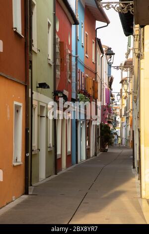 Tourisme en Vénétie et point d'intérêt parmi les ruelles étroites et les maisons maritme à Caorle port avec des vélos et des maisons colorées. Banque D'Images