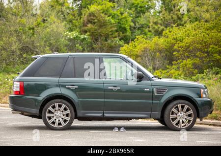 Green Range Rover sur une plage de Southampton avec des chaussures au sol Banque D'Images