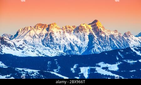 Vue panoramique sur les montagnes d'hiver. Sommets alpins couverts de neige et illuminés par le soleil levant. Banque D'Images