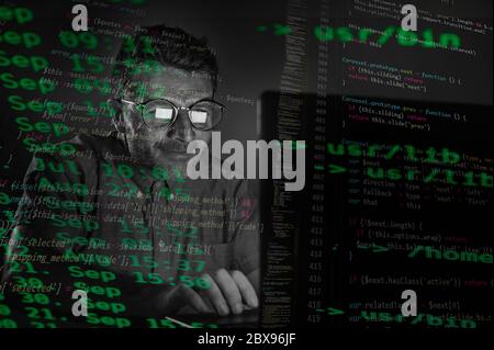 bizarre tidy et nerd hacker homme dans de grandes lunettes de programmation et de piratage ordinateur portable système entrant code dangereux tard dans la nuit dans la nuit tombée de la nuit Banque D'Images