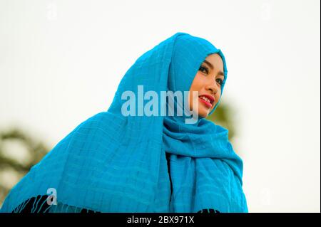 Style de vie isolé blanc fond portrait de jeune belle et heureuse femme asiatique en plein air dans le hijab bleu foulard musulman tête souriant gai lookin Banque D'Images