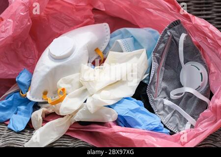 Masque médical de déchets sales et gants dans poubelle, articles d'équipement de maladie de coronavirus Banque D'Images