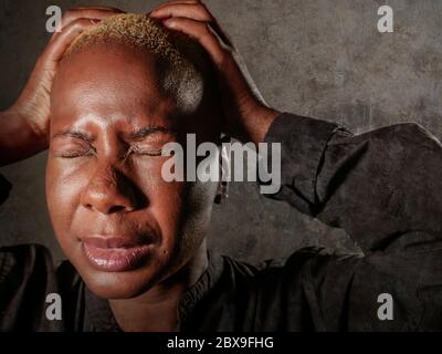 jeune femme noire afro-américaine triste et déprimée, qui pleure de désespoir en tenant la tête des mains se sentant misérable et désespéré souffrant depressi Banque D'Images