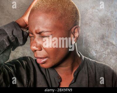 jeune femme noire afro-américaine triste et déprimée, qui pleure de désespoir en tenant la tête avec la main se sentant misérable et désespéré souffrant depressio Banque D'Images