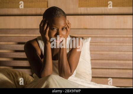 Jeune femme africaine américaine noire triste et déprimée dans un lit sans sommeil tard dans la nuit se sentant désespéré regardant inquiet et anxieux souffrant de dépression pr Banque D'Images