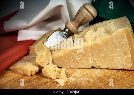 Gros plan du parmesan sur une planche à découper en bois avec couteau et drapeau italien Banque D'Images