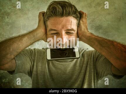 portrait dramatique de malade et fou stressé homme piquant téléphone mobile hurlant désespéré et hystérique regardant comme un weirdo dans la vie problème et le stress Banque D'Images