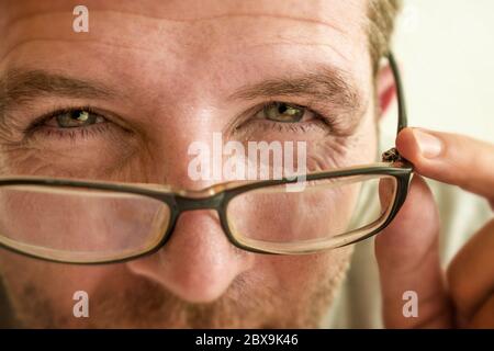 gros plan portrait du visage de l'homme vérifiant la vision essayant des lunettes à l'optométriste . guy 40s pendant l'examen optique des lunettes de correction de la myopie Banque D'Images