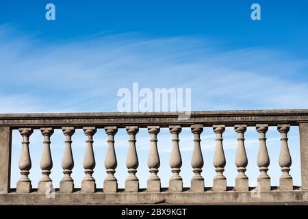 Gros plan d'une balustrade en béton sur un ciel bleu avec des nuages et un espace de copie. Banque D'Images