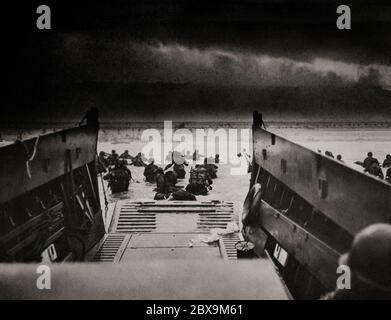 Des hommes du 16e Régiment d'infanterie, US 1st Infantry Division se frayent à terre sur Omaha Beach le matin du 6 juin 1944 pour participer à l'invasion alliée de la Normandie dans l'opération Overlord pendant la Seconde Guerre mondiale Nommé opération Neptune et souvent appelé jour J, il s'agissait de la plus grande invasion maritime de l'histoire. L'opération a commencé la libération de la France occupée par l'Allemagne (et plus tard l'Europe occidentale) et a posé les bases de la victoire des alliés sur le Front occidental. Banque D'Images