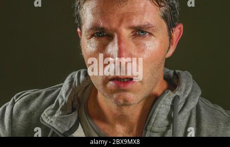 gros plan visage en sweat portrait d'un jeune homme attrayant et féroce portant un chandail sport posant dans une attitude agressive et provocante isolée sur d Banque D'Images