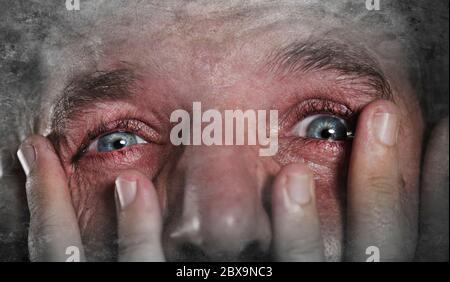 gros plan portrait dramatique du jeune homme avec les yeux expressifs pleurant désespérément dans la peur et l'horreur se sentant anxieux et déprimé se sentant désespoir et sa Banque D'Images
