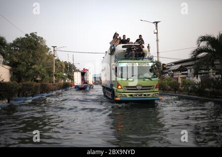 Jakarta, Indonésie. 06e juin 2020. Un camion chargé de personnes traverse une rue inondée de rob à Jakarta.Rob inondations à Jarkata, c'est un phénomène où l'eau de mer déborde sur le continent. Il peut également être interprété comme une flaque d'eau sur les terres côtières qui se produit lorsque les eaux de marée sont élevées ainsi inundate parties de la plaine côtière. Crédit : SOPA Images Limited/Alamy Live News Banque D'Images