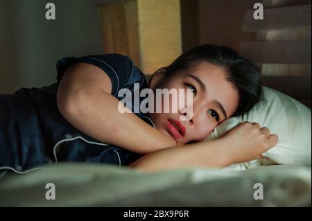 Accueil style de vie portrait de jeune belle triste et déprimé asiatique femme chinoise éveillé dans le lit tard la nuit souffrant de crise d'anxiété et de dépression probl Banque D'Images