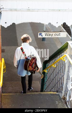 Woodbridge, Suffolk, Royaume-Uni septembre 20 2020: Une femme de 20 quelque chose de relaxant et posant avec sa guitare acoustique Banque D'Images