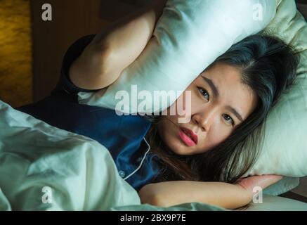 Accueil style de vie portrait de jeune belle triste et déprimé asiatique femme chinoise éveillé dans le lit tard la nuit souffrant de crise d'anxiété et de dépression probl Banque D'Images