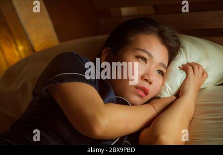 Accueil style de vie portrait de jeune belle triste et déprimé asiatique femme coréenne éveillé dans le lit tard la nuit souffrant de crise d'anxiété et de dépression proble Banque D'Images