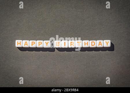 Carte postale de joyeux anniversaire avec lettres orange sur fond gris Banque D'Images