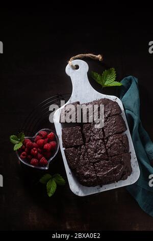 tarte au chocolat et au brownie végétalien avec tahini et framboises fraîches sur fond sombre Banque D'Images