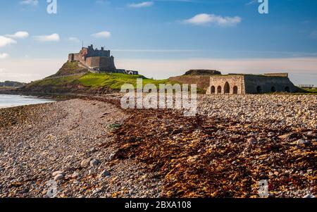 Le château de Lindisfarne et les fours à chaux le long de la plage depuis Castle point sur l'île Sainte, Northumberland, Angleterre Banque D'Images