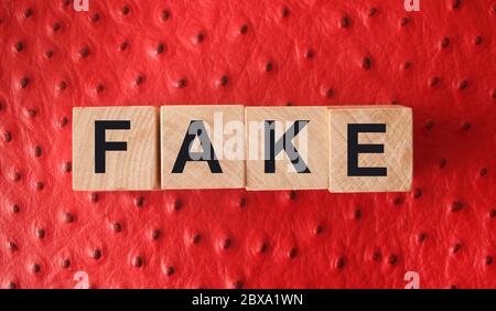 FAUX mot écrit en blocs de bois sur cuir rouge. Fausses nouvelles ou vraies nouvelles, mythe ou concept vrai Banque D'Images