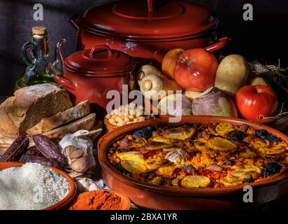 Riz valencien cuit au four avec porc, saucisse de sang ail tomates safran légumes. Cuisine typique Communauté Valencienne. Scène dans la cuisine Banque D'Images