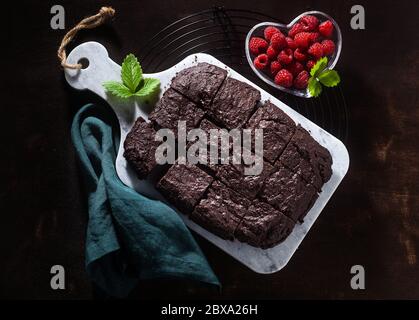 tarte au chocolat et au brownie végétalien avec tahini et framboises fraîches sur fond sombre Banque D'Images