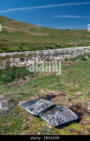 Les déchets sont partis après un barbecue dans un endroit de beauté rurale sur les rives de la rivière Eden, Mallerstang, près de Kirkby Stephen, Cumbria, Royaume-Uni. Banque D'Images