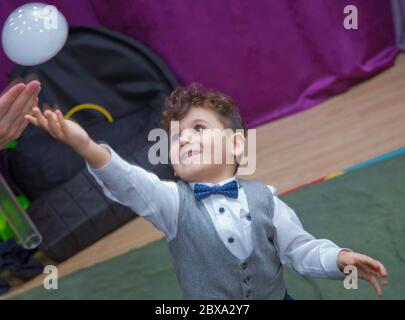 Joli petit garçon attrapant des bulles de savon . Petit garçon blond jouant avec des bulles de savon . Enfants à la fête. Des bulles de savon apparaissent. Fête d'enfants. À Banque D'Images