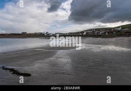 Plage avec des ondulations et des algues dans le sable et des gens et des chiens au loin à Port Logan, Dumfries & Galloway, Écosse Banque D'Images