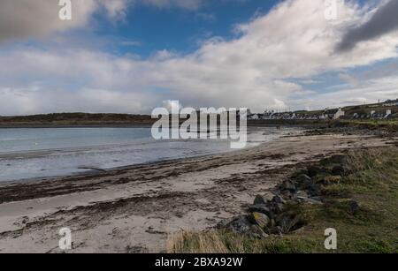 Plage et estran herbacé à marée basse avec des ondulations et des algues dans le sable et des gens au loin Port Logan, Dumfries & Galloway, Écosse Banque D'Images