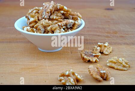 Plateau de noyau de noyer biologique et de noyau de noyer répandu sur fond de bois Banque D'Images