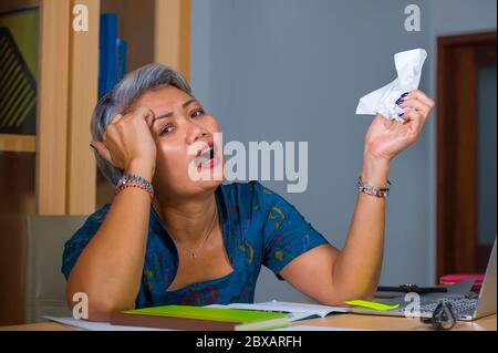 portrait de style de vie de bureau de dépression et surtravaillé d'âge moyen attrayante femme asiatique travaillant en stress sur ordinateur portable bureau se sentant bouleversé et o Banque D'Images