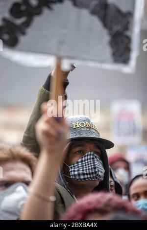Homme mouillé de pluie, portant une casquette de baseball et un masque facial, tenant un panneau à la Black Lives Matter UK Protest, Parliament Square, Londres, Angleterre, Royaume-Uni Banque D'Images