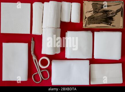 Intérieur d'une trousse de premiers soins isolée sur fond rouge Banque D'Images