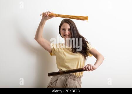 Une esthéticienne massante sourit et tient des bâtons de bambou dans ses mains. Studio tourné sur fond blanc. Pour les articles et le service de publicité Banque D'Images