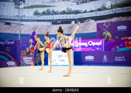 12-03-2020 KAZAN, RUSSIE: Des filles adolescentes en costumes rouges qui se sont performances avec des balles sur le tournoi de gymnastique. Photo intermédiaire Banque D'Images