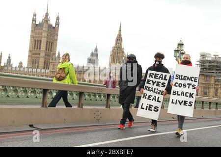 Des manifestants ont tenu des pancartes BLM sur le pont de Westminster pendant la manifestation.des centaines de manifestants ont convergé sur la place du Parlement pour une paisible manifestation de Black Lives Matter en signe de respect envers l'américain George Floyd. La majorité des manifestants avaient des EPI et des organisateurs avaient remis à tous ceux qui avaient besoin de masque et de gants. Banque D'Images