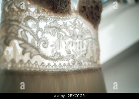 Macro photo de dentelle partie de robe de mariage dans le dos-lumière. Ornements de fleurs et de plantes. Très faible profondeur de champ. Concept de mariage. Banque D'Images