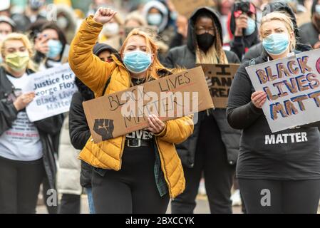 Black Lives Matter contre le racisme manifestation de protestation à Southend on Sea, Essex, Royaume-Uni. Étiquette de maintien blanche blanche pour femme avec poing relevé Banque D'Images