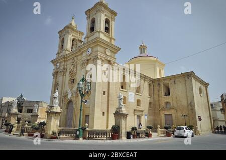 L'église catholique de l'Apôtre Saint Bartholomée, en centre-ville, vue du côté sud. Le bâtiment jaune baroque en pierre calcaire avec deux cl Banque D'Images