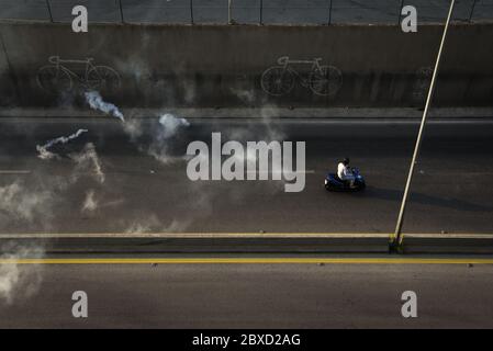 Beyrouth, Liban. 6 juin 2020. Un homme passe un scooter à travers des gaz de tarie après que les manifestations pacifiques se soient transformées en violence et que les manifestants se soient affrontés, l'armée et la police. Crédit : Elizabeth FITT/Alay Live News Banque D'Images