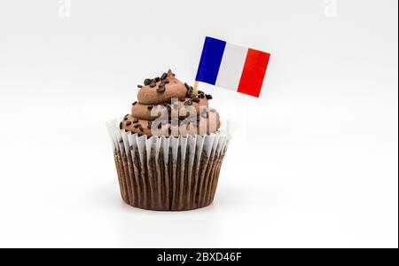 Un cupcake de chocolat au beurre avec un topic à dent tricolore à pavillon français isolé sur blanc Banque D'Images