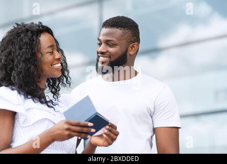 Portrait d'un couple noir heureux avec passeports et billets entre les mains Banque D'Images